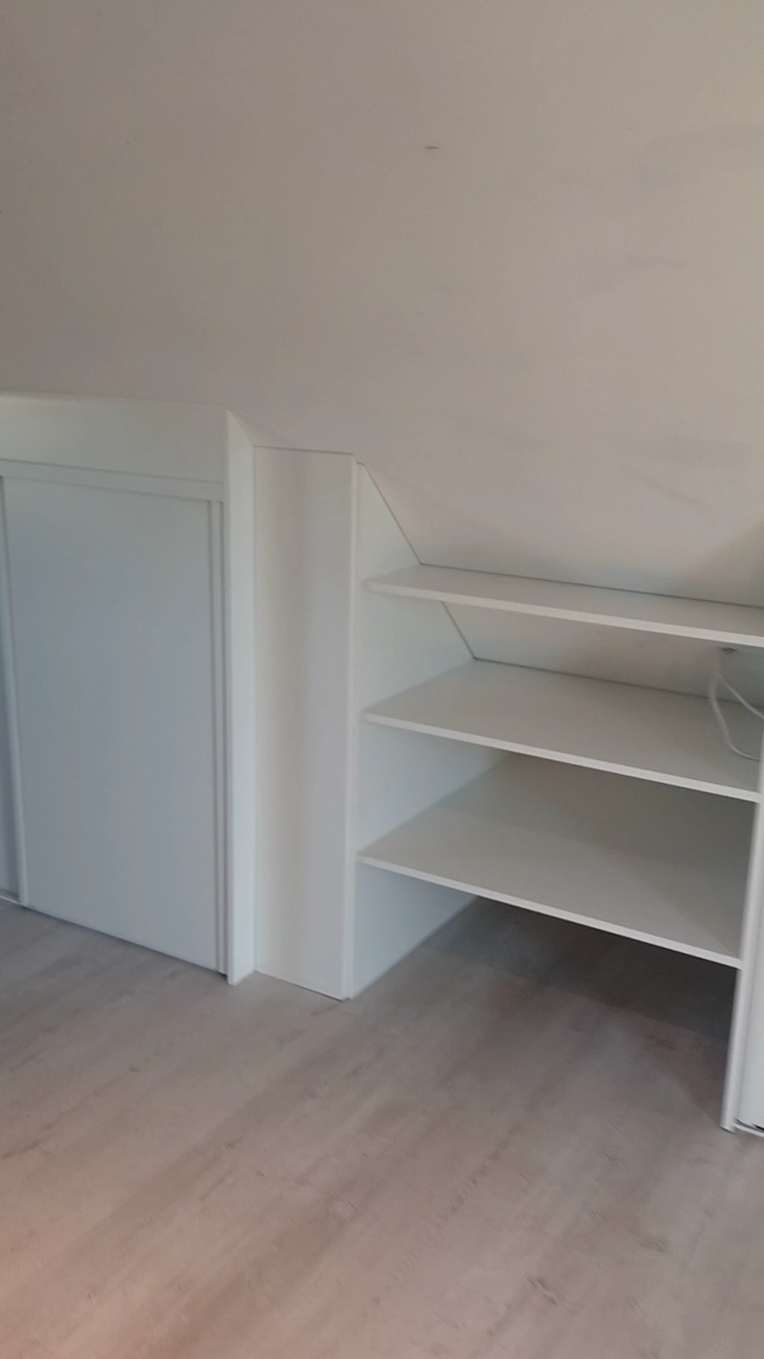 Szafa przesuwna pod skosem dachu — biała zabudowa Meble Okaro